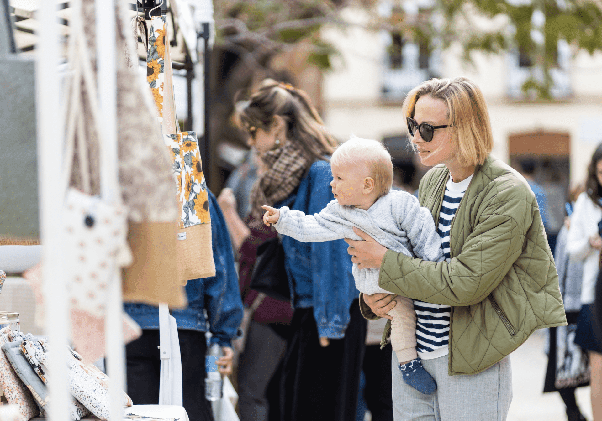Woman on flea market holding her child in her arms